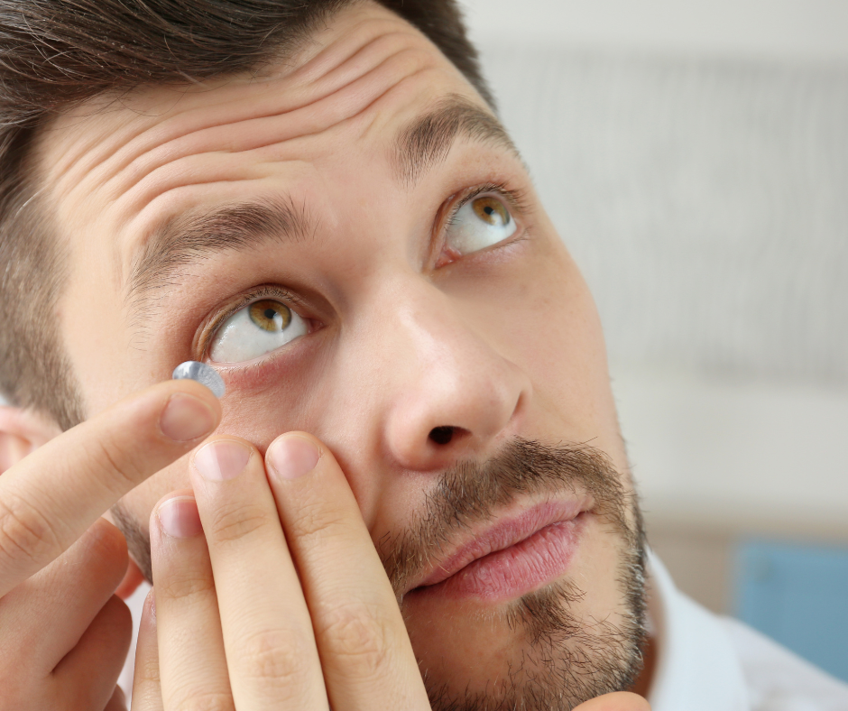 Man putting contact lens into eye